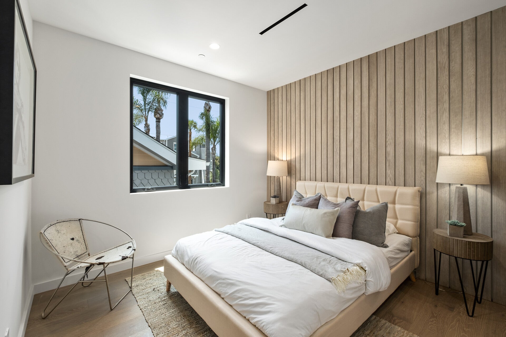 Bedroom with vertical wood paneling and a fireplace