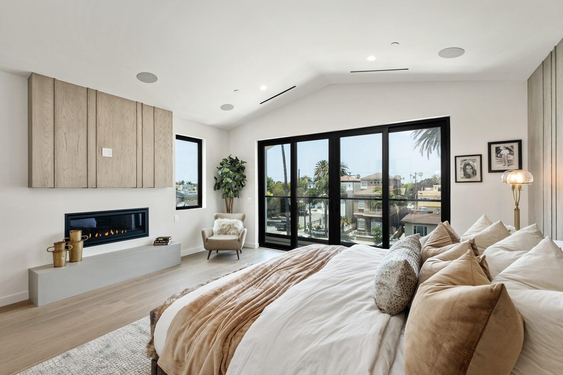 Bedroom with a vaulted ceiling and large windows